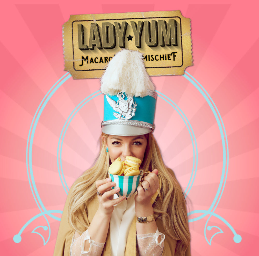 Lady Yum Megan Wagstaff in a marching band hat and a mug of macarons. 